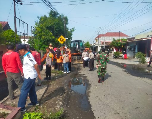 Sinergitas Polisi Bersama TNI dan Warga Bersihkan Parit Limbah Pabrik di Ngawi