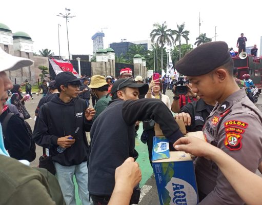 Polisi Bagikan Air Mineral dan Roti kepada Buruh di Depan DPR/MPR