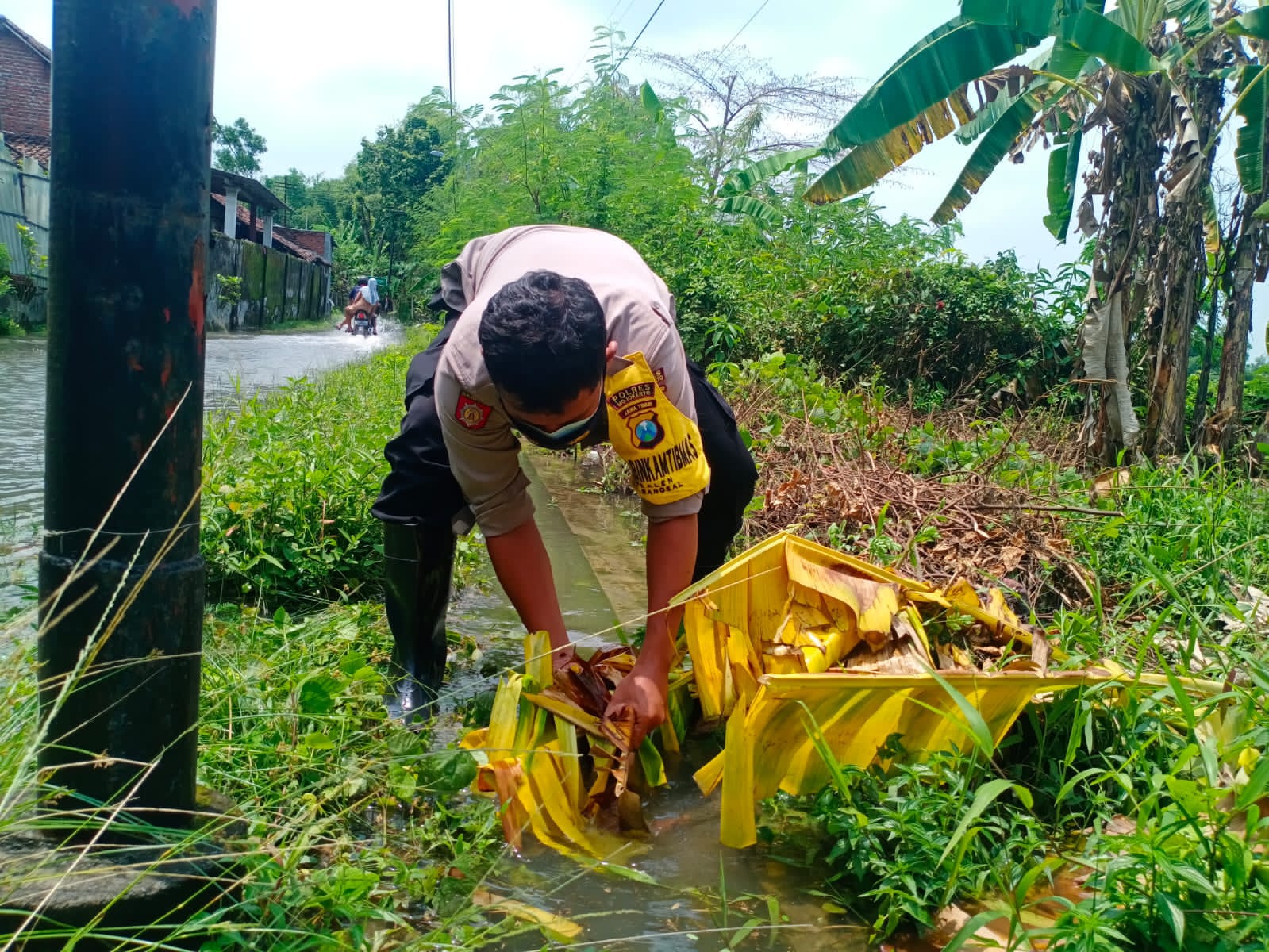 Antisipasi Banjir, Bhabinkamtibmas Polres Mojokerto Bersama Warga Bersihkan Saluran Air