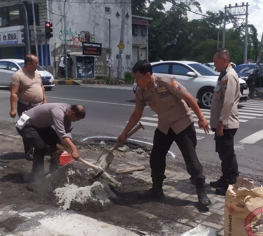 Polisi Bersama TNI dan Warga Tambal Jalan Berlubang di Kota Malang Cegah Kecelakaan