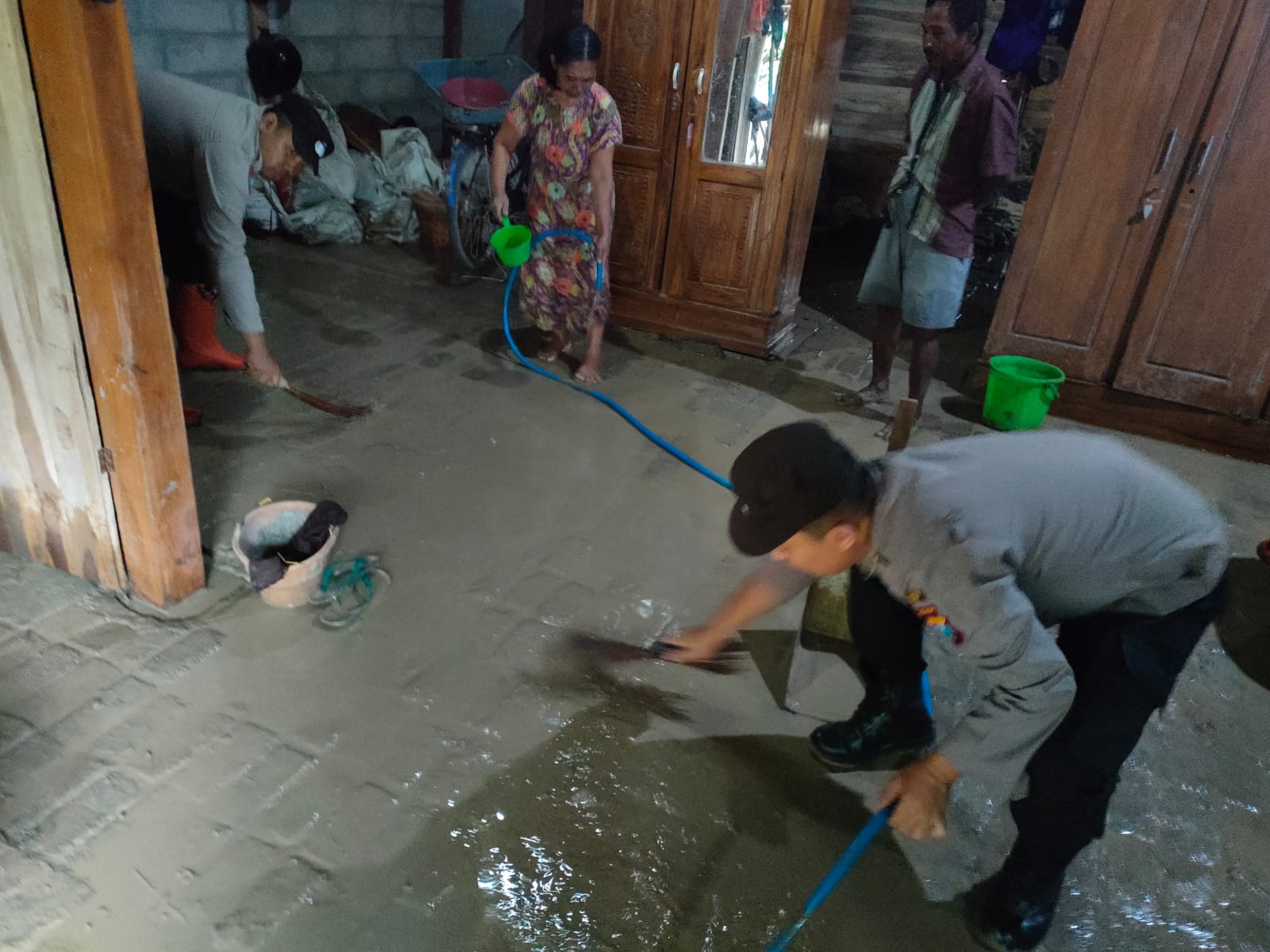 Kompak, Polisi Bersama Warga Bersihkan Sisa Lumpur Akibat Banjir di Ngawi