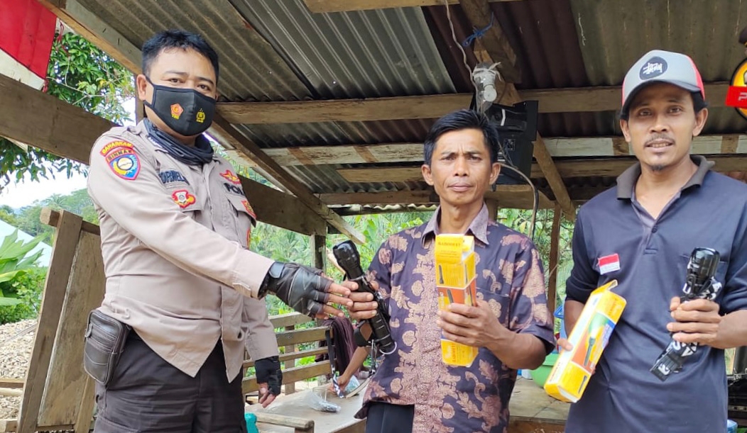 Support Siskamling di Batu Patah, Bhabinkamtibmas Polres Tanggamus Berikan Senter Swat Police